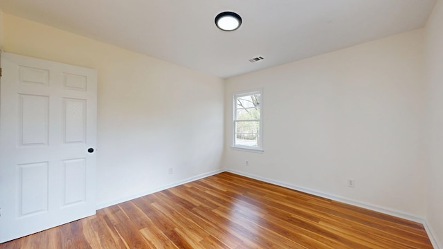 empty room with baseboards and light wood-type flooring