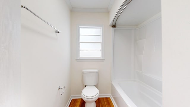 bathroom with crown molding, toilet, wood finished floors, and baseboards