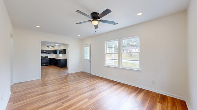 unfurnished living room featuring recessed lighting, baseboards, a ceiling fan, and light wood finished floors