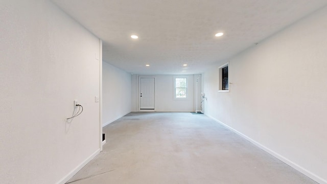 unfurnished room featuring recessed lighting, concrete flooring, and baseboards