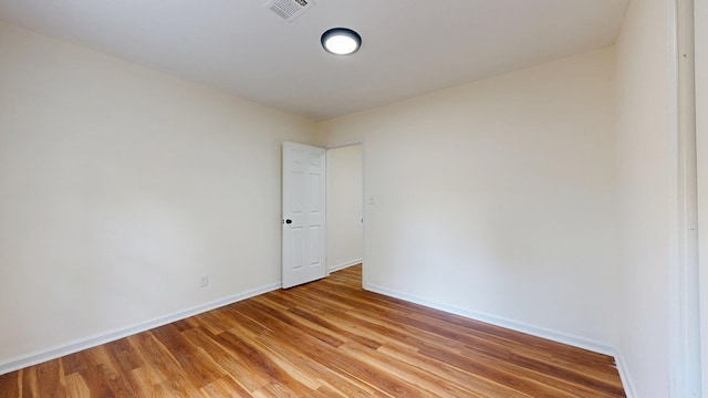 spare room featuring visible vents, baseboards, and light wood finished floors