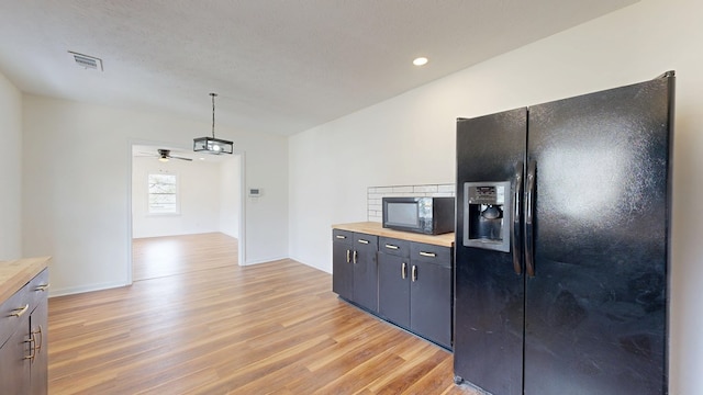 kitchen featuring wood counters, black appliances, light wood-style flooring, and visible vents