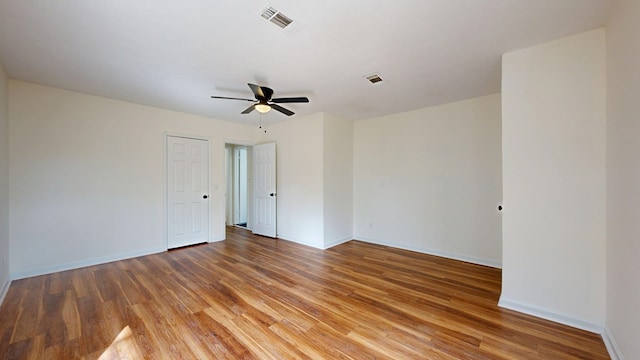 spare room featuring light wood-style flooring, baseboards, and visible vents