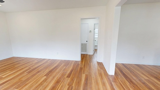 spare room featuring visible vents, light wood-style flooring, and baseboards