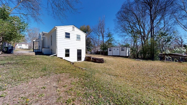 exterior space featuring a yard, an outbuilding, and a storage shed