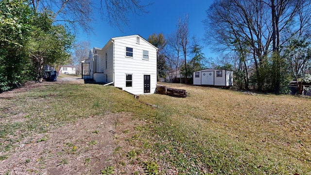 rear view of house with a shed, a lawn, and an outdoor structure