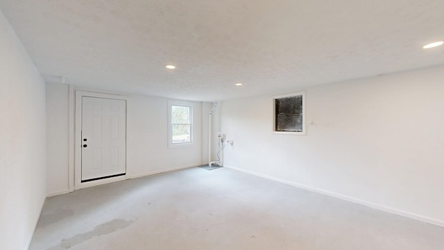 empty room with recessed lighting, baseboards, concrete flooring, and a textured ceiling