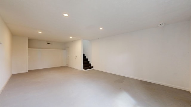 empty room with visible vents, baseboards, recessed lighting, stairs, and concrete flooring