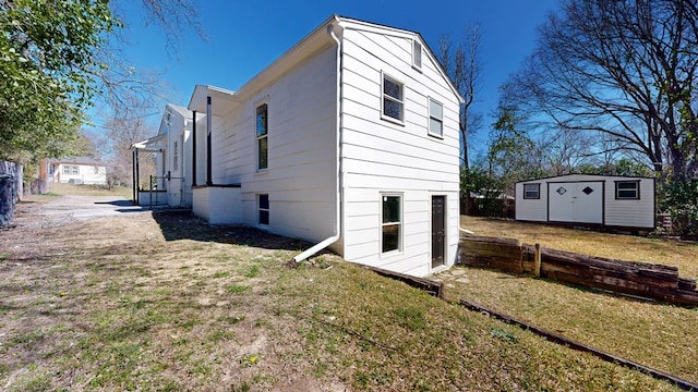 view of side of property featuring a yard, a storage unit, an outdoor structure, and fence