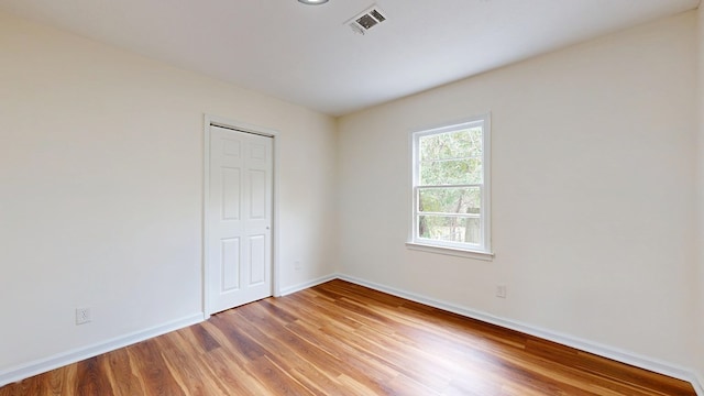 unfurnished room featuring visible vents, baseboards, and light wood finished floors