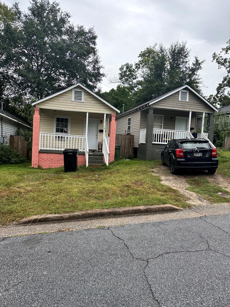 bungalow with a front lawn and covered porch