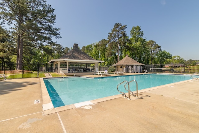 pool featuring a gazebo, a patio area, and fence