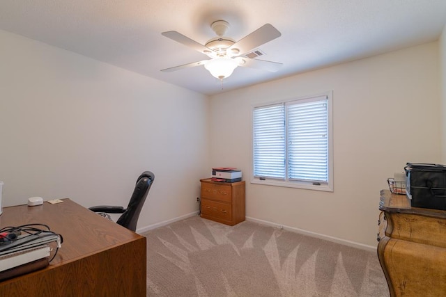 office space with baseboards, visible vents, a ceiling fan, and light colored carpet