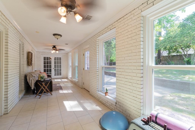 sunroom with a ceiling fan, visible vents, and a healthy amount of sunlight