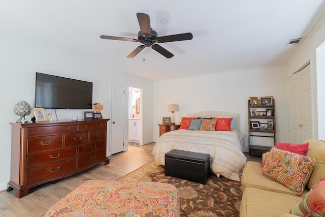 bedroom featuring visible vents, light wood finished floors, a ceiling fan, and ensuite bathroom