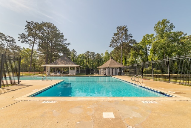 pool with fence, a patio area, and a gazebo