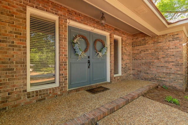 view of exterior entry featuring brick siding