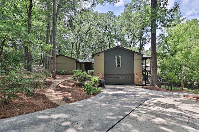 2707 Lookout Dr, Columbus, GA 31906 - view of front facade featuring stone siding, driveway, a garage, stairway, and view of wooded area