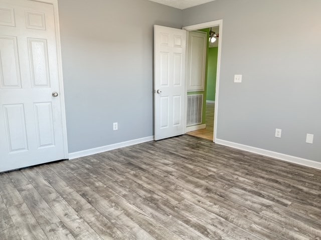 unfurnished bedroom with baseboards and wood finished floors