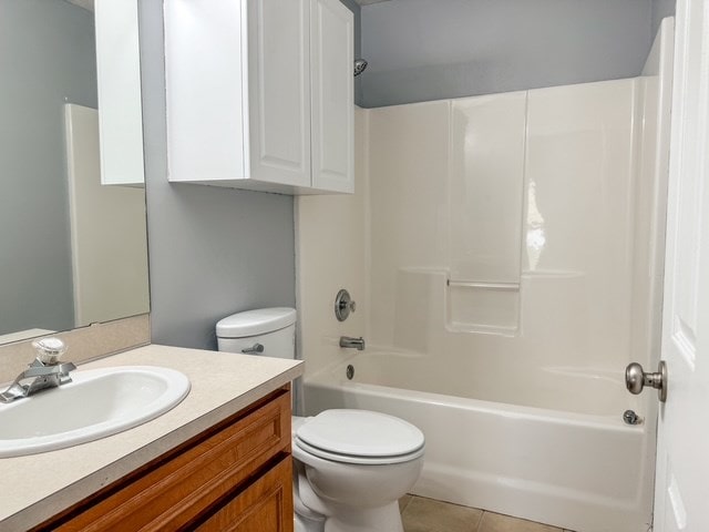 full bath featuring tile patterned flooring, toilet, vanity, and shower / bath combination