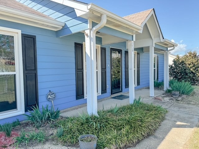 view of side of home featuring covered porch