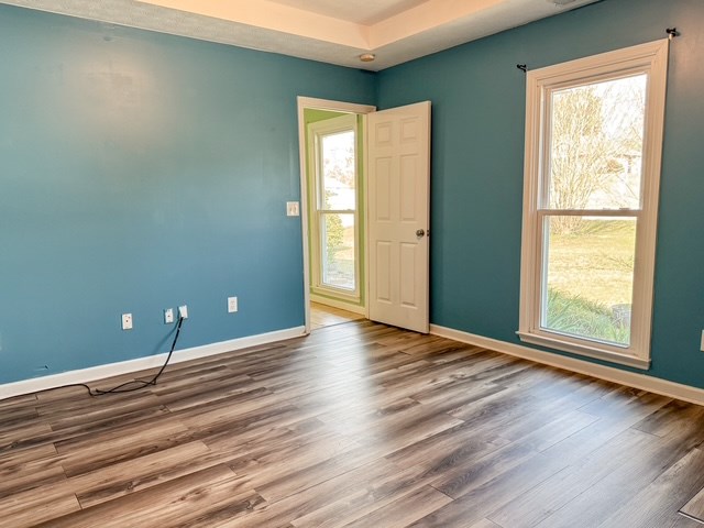 empty room with wood finished floors and baseboards