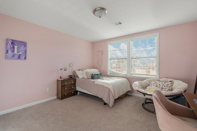 bedroom featuring light carpet, ceiling fan, and a tray ceiling