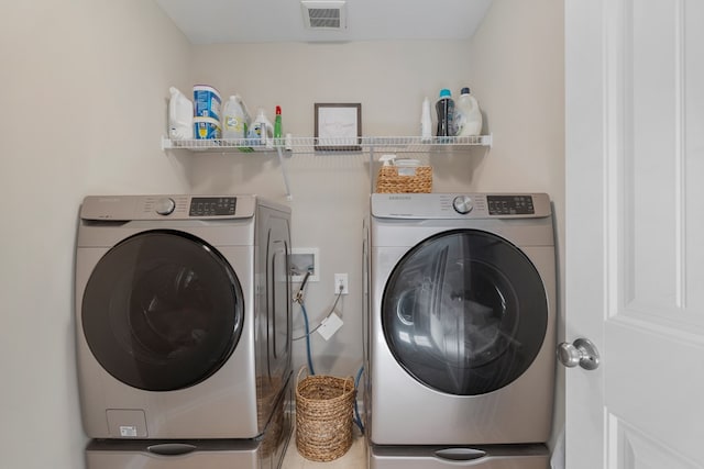 clothes washing area with separate washer and dryer