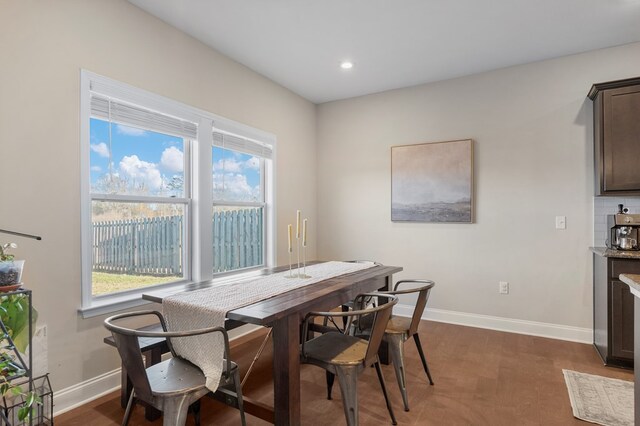 kitchen with a center island with sink, appliances with stainless steel finishes, pendant lighting, dark hardwood / wood-style flooring, and sink