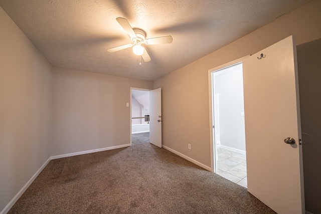 carpeted empty room with ceiling fan and a textured ceiling