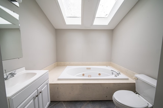 bathroom with vanity, toilet, a skylight, and a bathtub