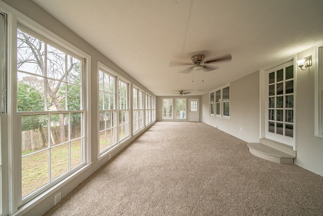 unfurnished sunroom featuring ceiling fan