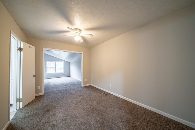 empty room with ceiling fan, lofted ceiling, carpet, and a textured ceiling