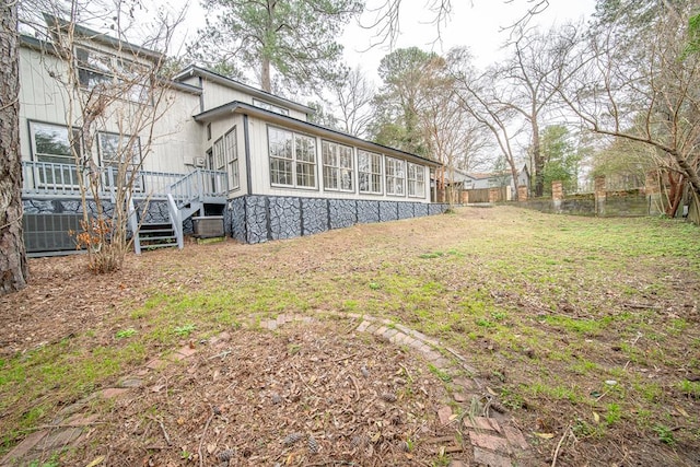 view of yard featuring a sunroom and a deck