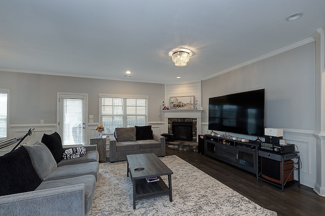 living room with a fireplace, ornamental molding, and dark wood-type flooring