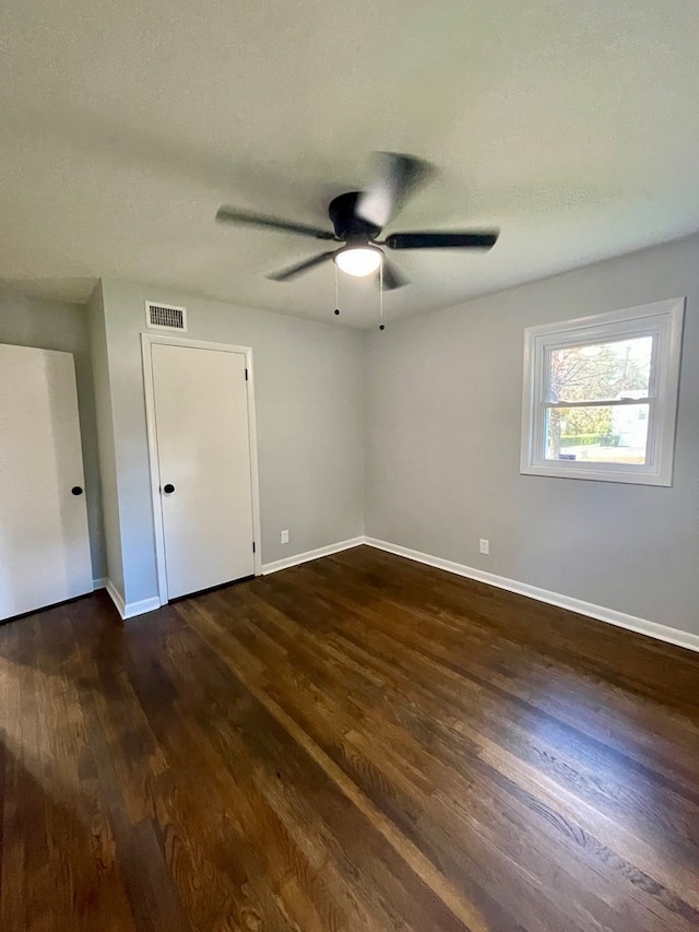 unfurnished bedroom featuring ceiling fan and dark hardwood / wood-style floors