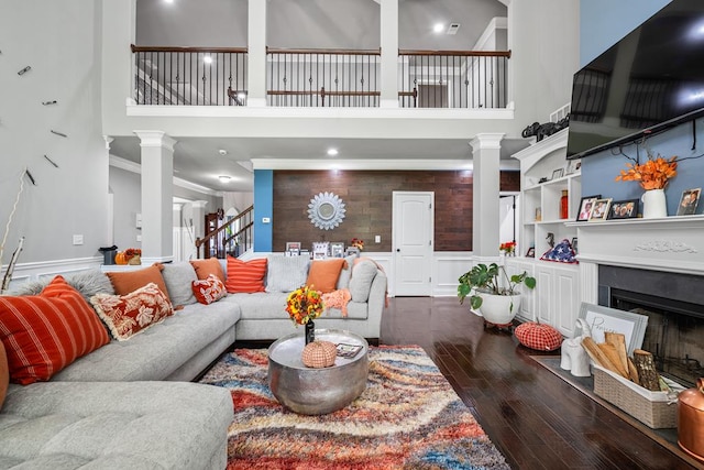 50 Riverside Lndg, Fort Mitchell, AL 36856 - living room featuring wood-type flooring, a towering ceiling, stairway, a fireplace, and ornate columns