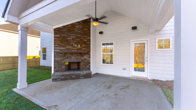 view of patio / terrace featuring an outdoor stone fireplace and fence