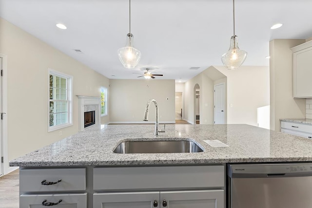 kitchen featuring visible vents, gray cabinetry, open floor plan, dishwasher, and a sink