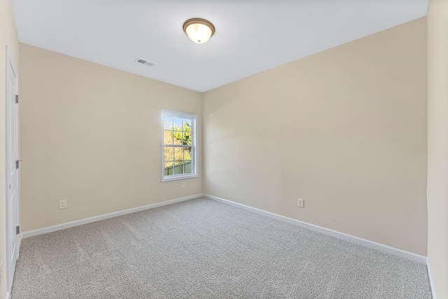 carpeted empty room with visible vents and baseboards