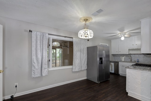 kitchen featuring backsplash, white cabinets, hanging light fixtures, dark hardwood / wood-style floors, and appliances with stainless steel finishes