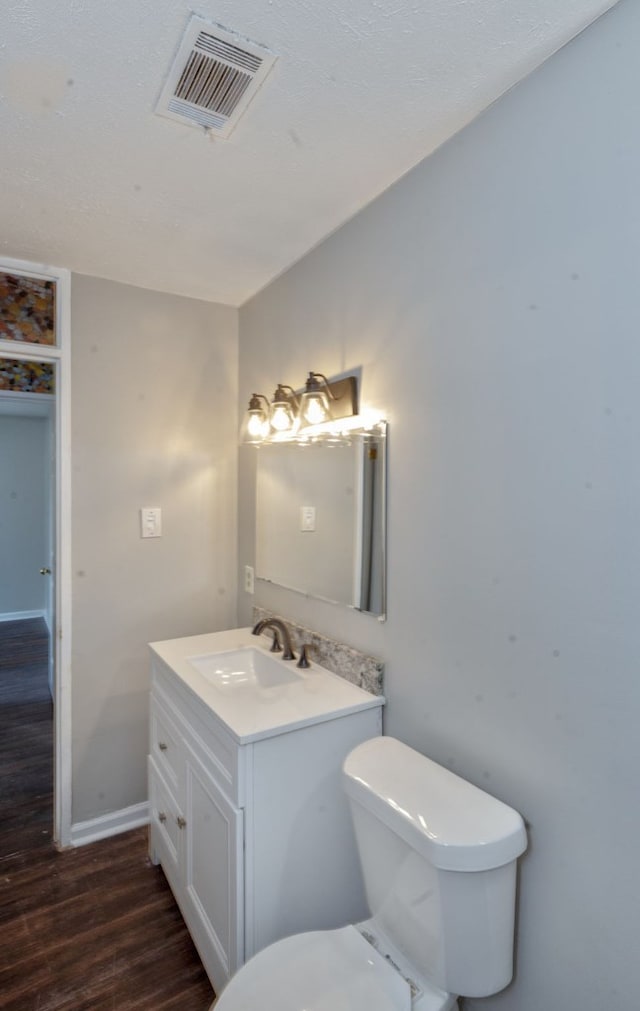 bathroom featuring vanity, hardwood / wood-style flooring, and toilet