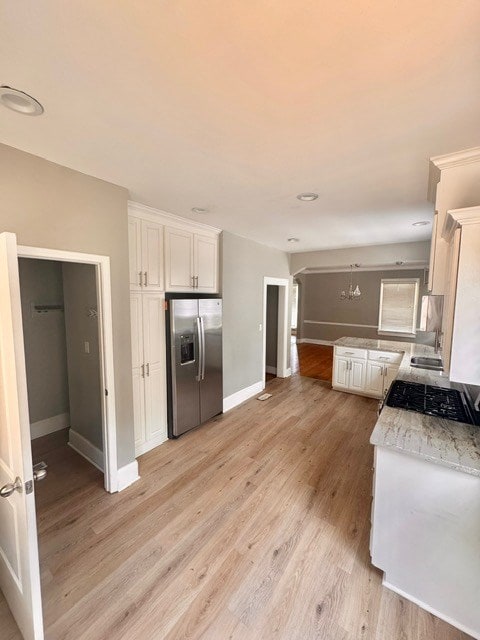 1616 Crest Dr, Columbus, GA 31906 - kitchen featuring stainless steel refrigerator with ice dispenser, white cabinets, light wood-type flooring, and light stone counters