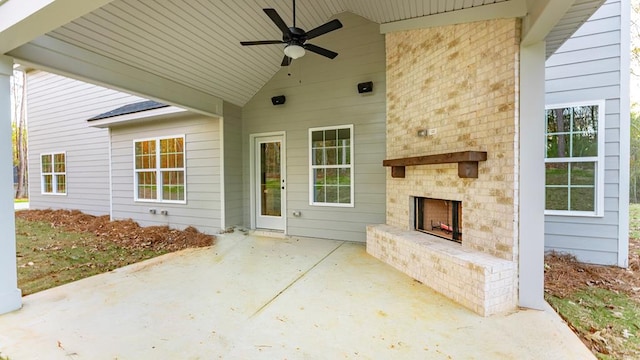 view of patio featuring an outdoor brick fireplace and ceiling fan