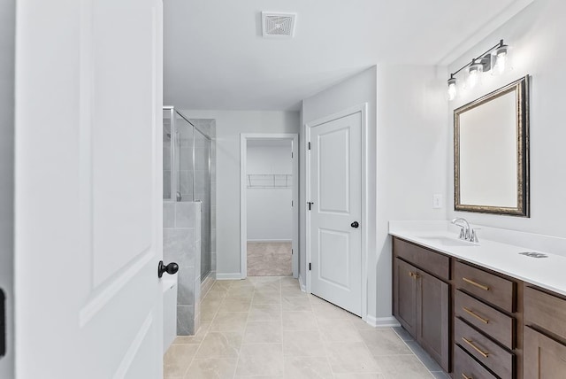 bathroom with tile patterned floors, vanity, and a shower with door