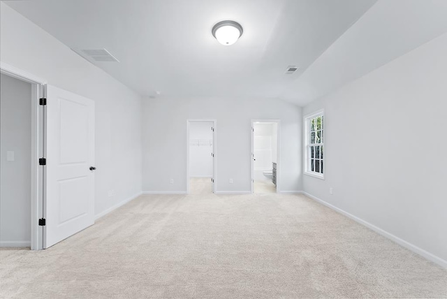 carpeted spare room featuring vaulted ceiling