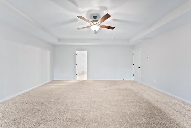 unfurnished room featuring light carpet, a raised ceiling, and ceiling fan