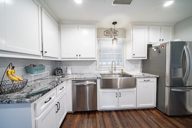 kitchen with visible vents, a sink, white cabinets, stainless steel appliances, and dark wood-style flooring