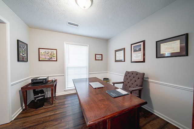 office space with dark wood finished floors, baseboards, visible vents, and a textured ceiling