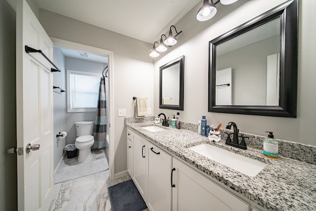 full bath with a sink, toilet, marble finish floor, and double vanity